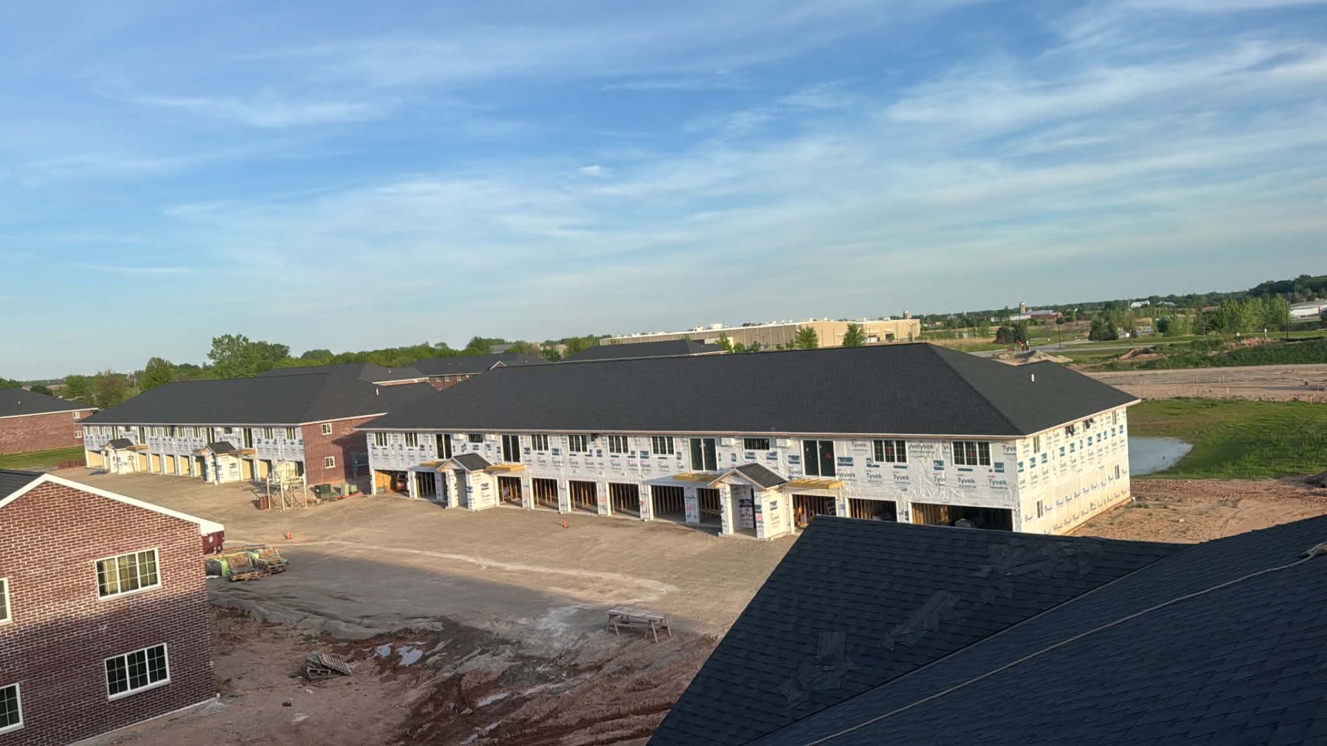 Aerial view of newly shingled townhome buildings under construction