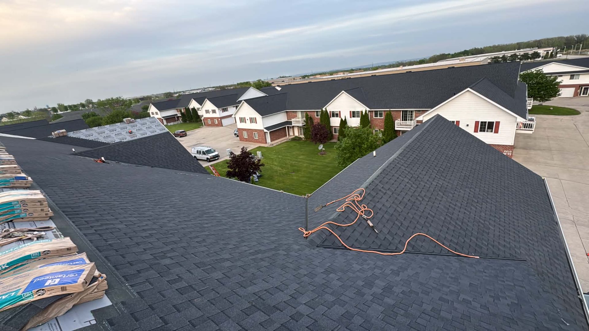 Aerial view of a completed architectural shingle roof on a multi-unit building